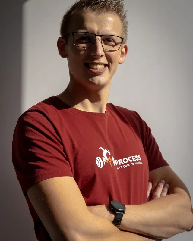 Ben Leppens, coach bij Process, lachend met gekruiste armen in een rode Process-shirt