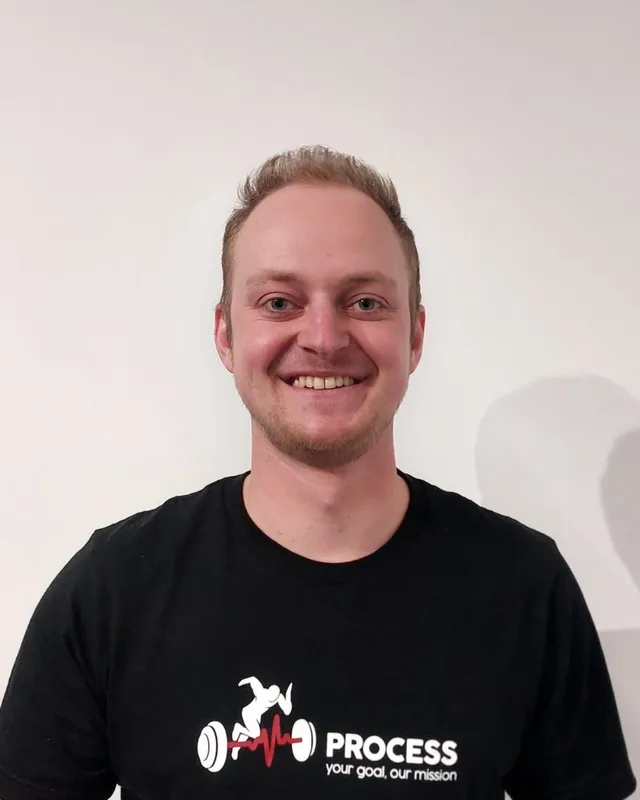 Lennert Jansen, coach bij Process, lachend in een zwarte Process-shirt